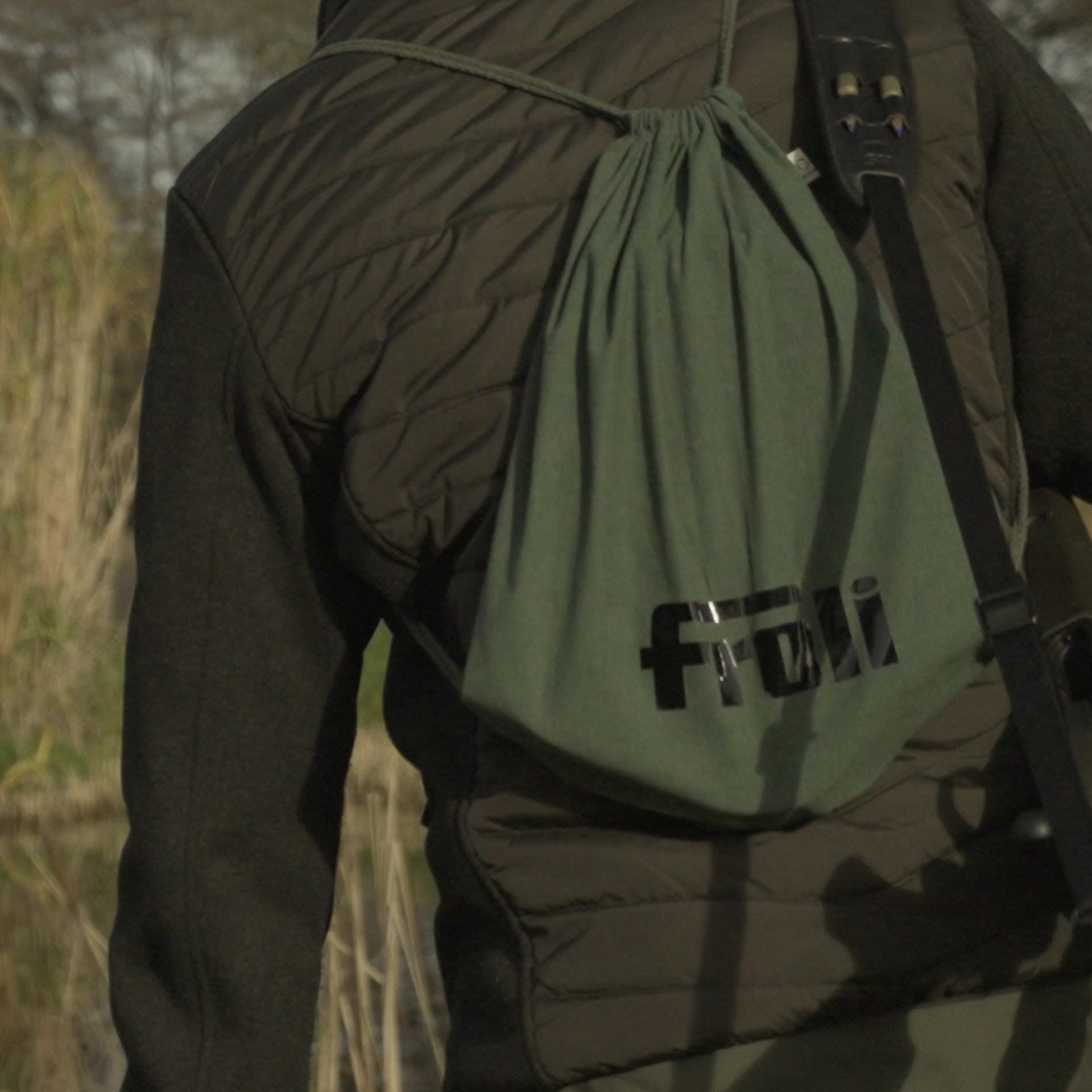 Person in Jagdkleidung trägt das Produkt in der grünen Tragetasche auf dem Rücken