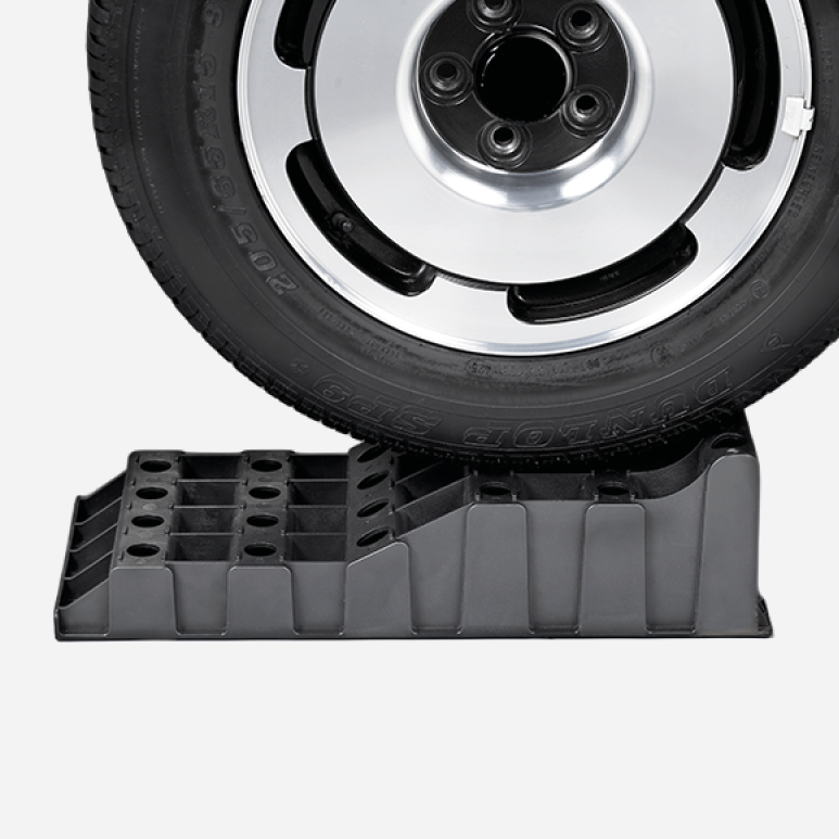 Fahrzeugrad auf einem schwarzen Froli Stufenkeil XL als Anwendungsbeispiel