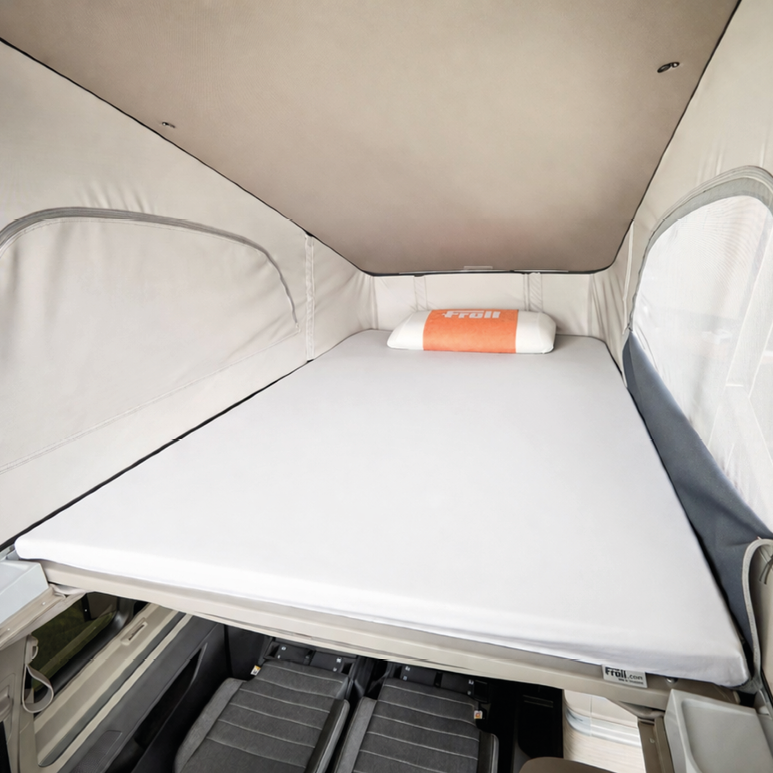 Dachbett eines VW California mit weißem Froli Spannbettlaken und Froli Kissen im hinteren Bereich; abgebildetes Kissen nicht im Lieferumfang enthalten