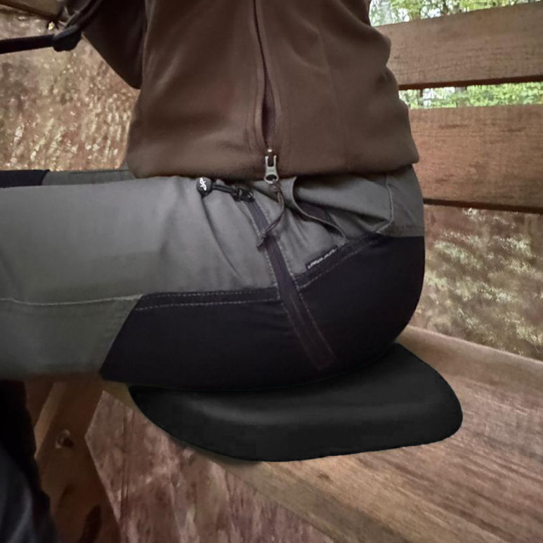 Person in Arbeitshose sitzt auf dem Sitzkissen auf einer Holzbank
